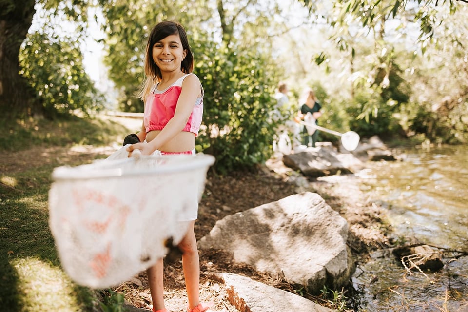 Ung tjej som håller i en håv vid vattnet